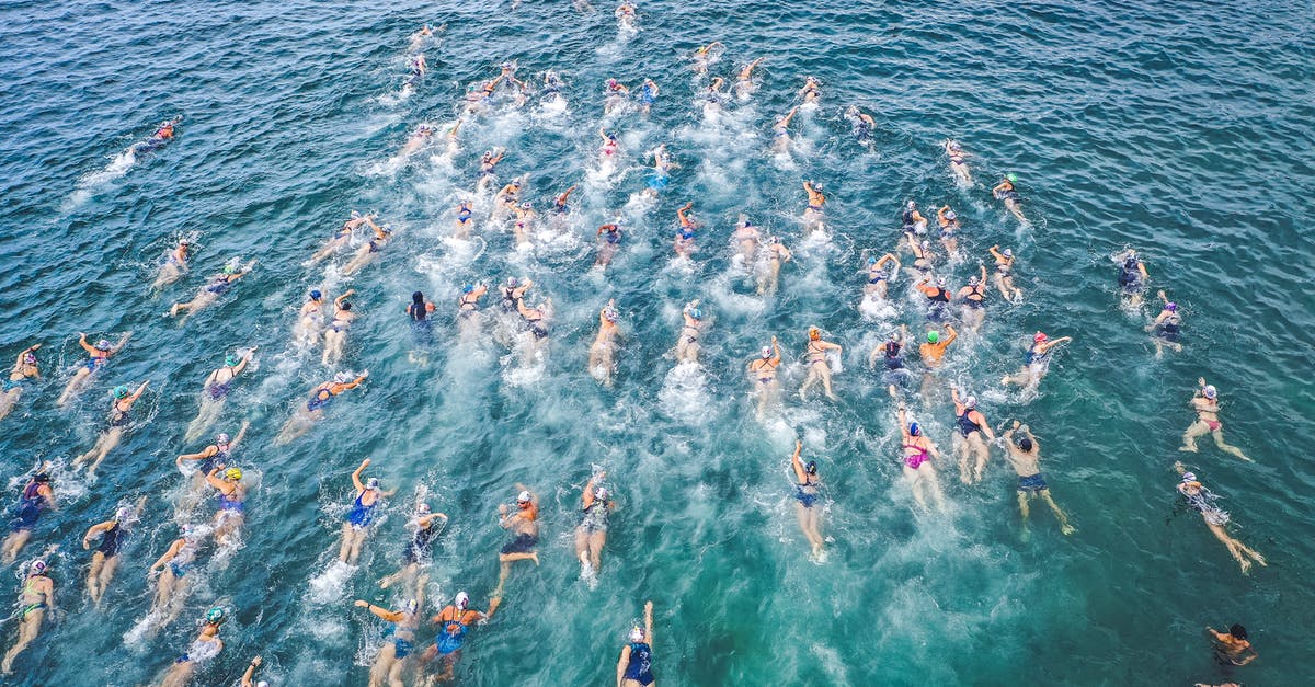Are the beaches in Rosarito Mexico clean enough for swimming? - Aerial view of challenge participants in swimsuits swimming forward in splashing clear water Are the beaches in Rosarito Mexico clean enough for swimming? - Aerial view of challenge participants in swimsuits swimming forward in splashing clear water