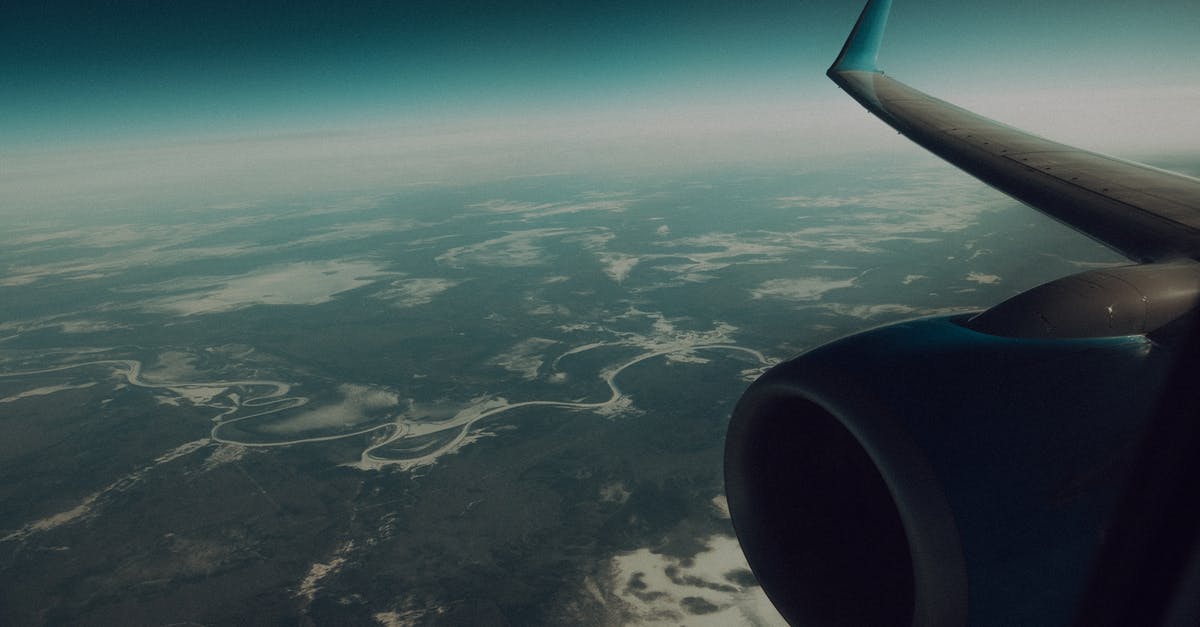 Are there any flights which fly above the Bermuda Triangle? - Through window of modern wing and turbine of airplane flying in sky above verdant land Are there any flights which fly above the Bermuda Triangle? - Through window of modern wing and turbine of airplane flying in sky above verdant land