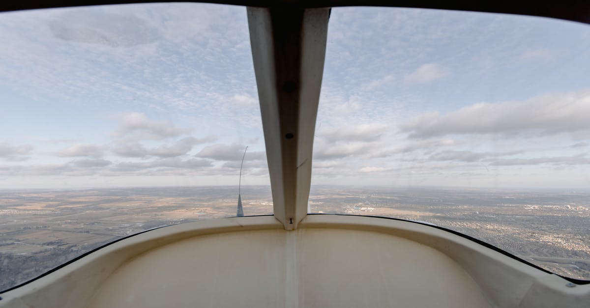 Are there any flights which fly above the Bermuda Triangle? - View through windshield of aircraft cockpit soaring over vast plain land under cloudy sky Are there any flights which fly above the Bermuda Triangle? - View through windshield of aircraft cockpit soaring over vast plain land under cloudy sky