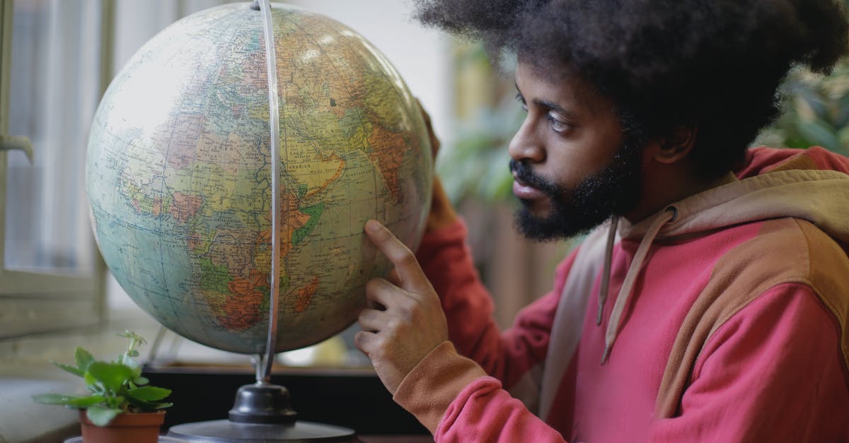 Are there any man-only places in the world? - Thoughtful young bearded ethnic man with globe sitting at table in modern room Are there any man-only places in the world? - Thoughtful young bearded ethnic man with globe sitting at table in modern room
