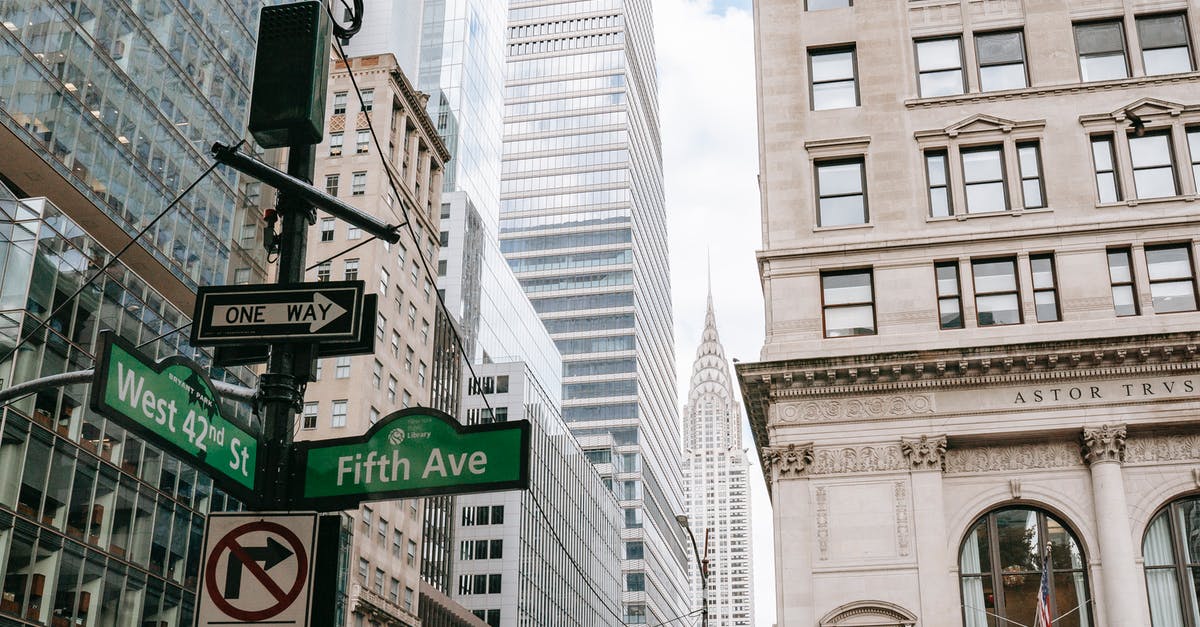 Are there any resorts in the NYC area? - Low angle of road sign on pillar with traffic light located in city on avenue with modern skyscrapers and residential buildings Are there any resorts in the NYC area? - Low angle of road sign on pillar with traffic light located in city on avenue with modern skyscrapers and residential buildings