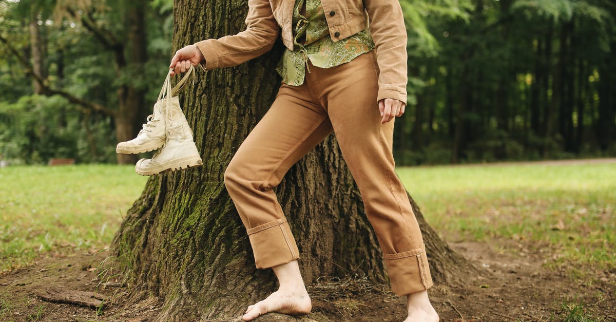 Are there any restrictions in carrying shoes in cabin baggage? - Unrecognizable Woman Standing Barefoot Carrying a Pair of White Shoes Are there any restrictions in carrying shoes in cabin baggage? - Unrecognizable Woman Standing Barefoot Carrying a Pair of White Shoes