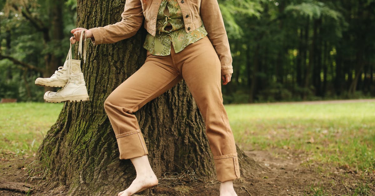 Are there any restrictions in carrying shoes in cabin baggage? - Woman in Green Jacket and Brown Pants Sitting on Tree Trunk Are there any restrictions in carrying shoes in cabin baggage? - Woman in Green Jacket and Brown Pants Sitting on Tree Trunk