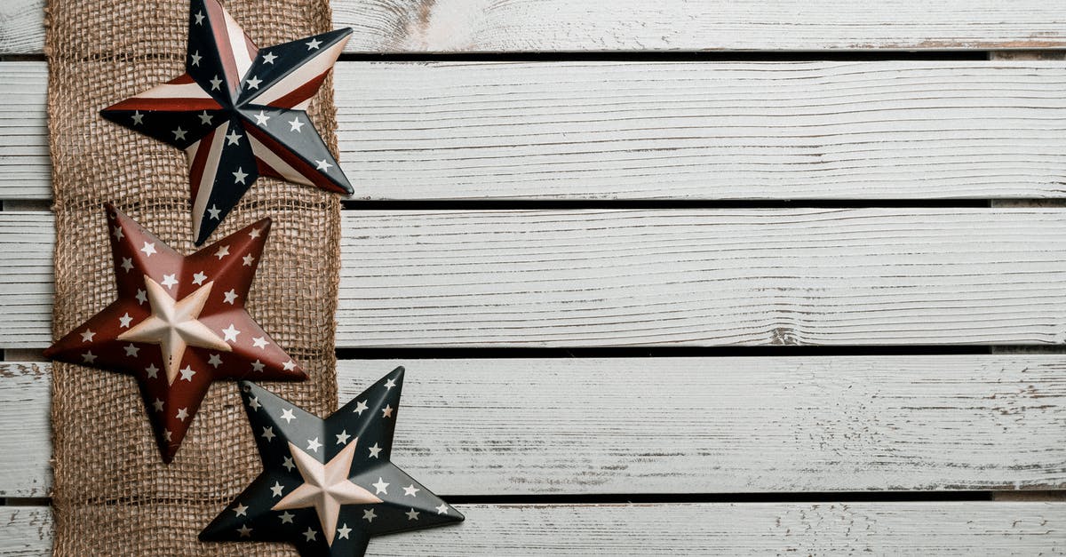 Are there countries other than the USA where you are required to collect your luggage even in transit? - Top view of arranged colorful stars in American style placed on fabric stripe on wooden background illustrating holiday celebration concept