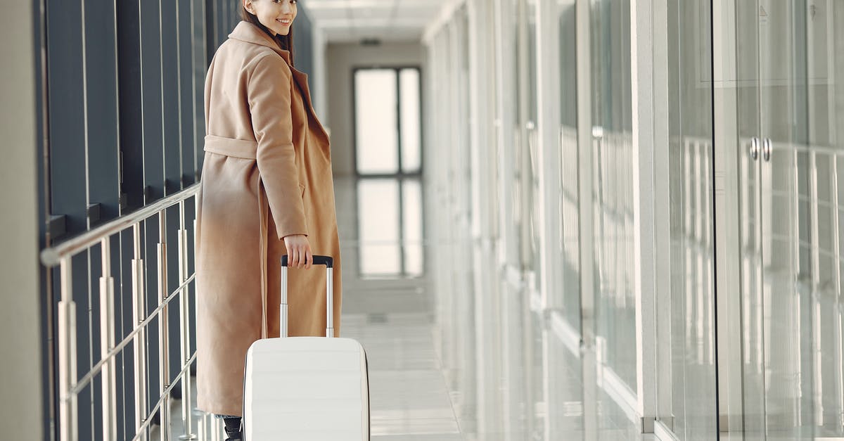 Are there flight tours over Antarctica? - Stylish happy traveler with suitcase in airport hallway Are there flight tours over Antarctica? - Stylish happy traveler with suitcase in airport hallway