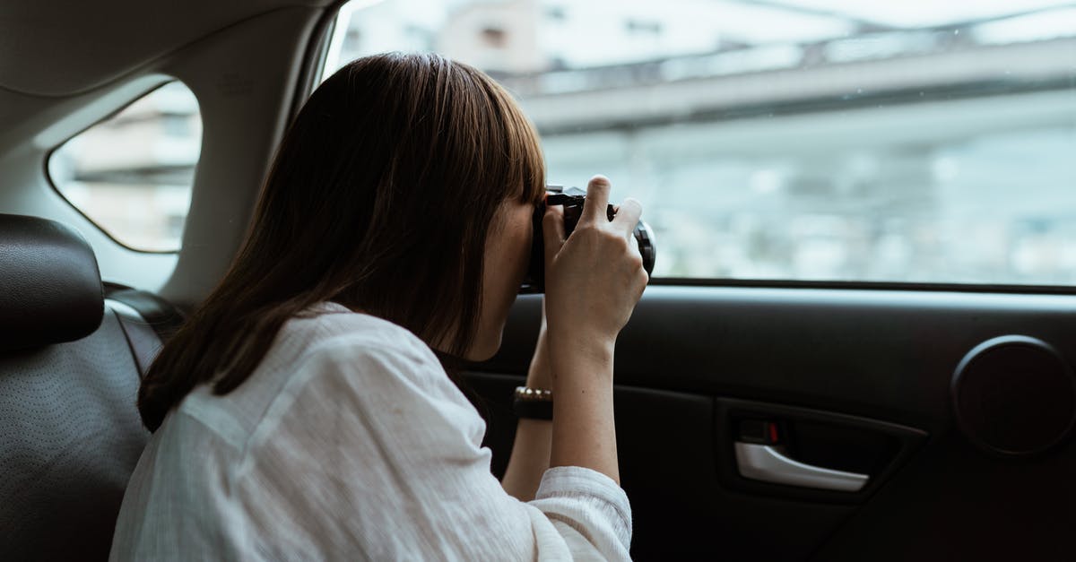 Are there issues with street photography in China when using a professional camera? - Woman taking photo on photo camera from car backseat Are there issues with street photography in China when using a professional camera? - Woman taking photo on photo camera from car backseat
