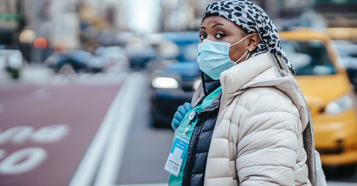 Are there limited term identification cards in the UK? - Side view of mature black female medic in outerwear with badge looking at camera on urban roadway Are there limited term identification cards in the UK? - Side view of mature black female medic in outerwear with badge looking at camera on urban roadway