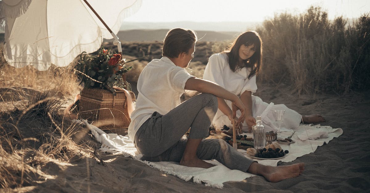 Are there other peaceful enclaves in the world like in Baerle-Nassau (Belgium/Nederlands)? [closed] - Young loving couple having romantic picnic sitting on white blanket with food and drinks under white umbrella