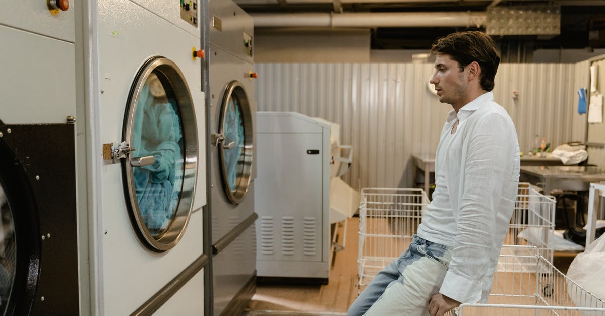 Are there self-service laundries in Arendal? - A Man Waiting For His Clothes in a Self-Service Laundry Are there self-service laundries in Arendal? - A Man Waiting For His Clothes in a Self-Service Laundry