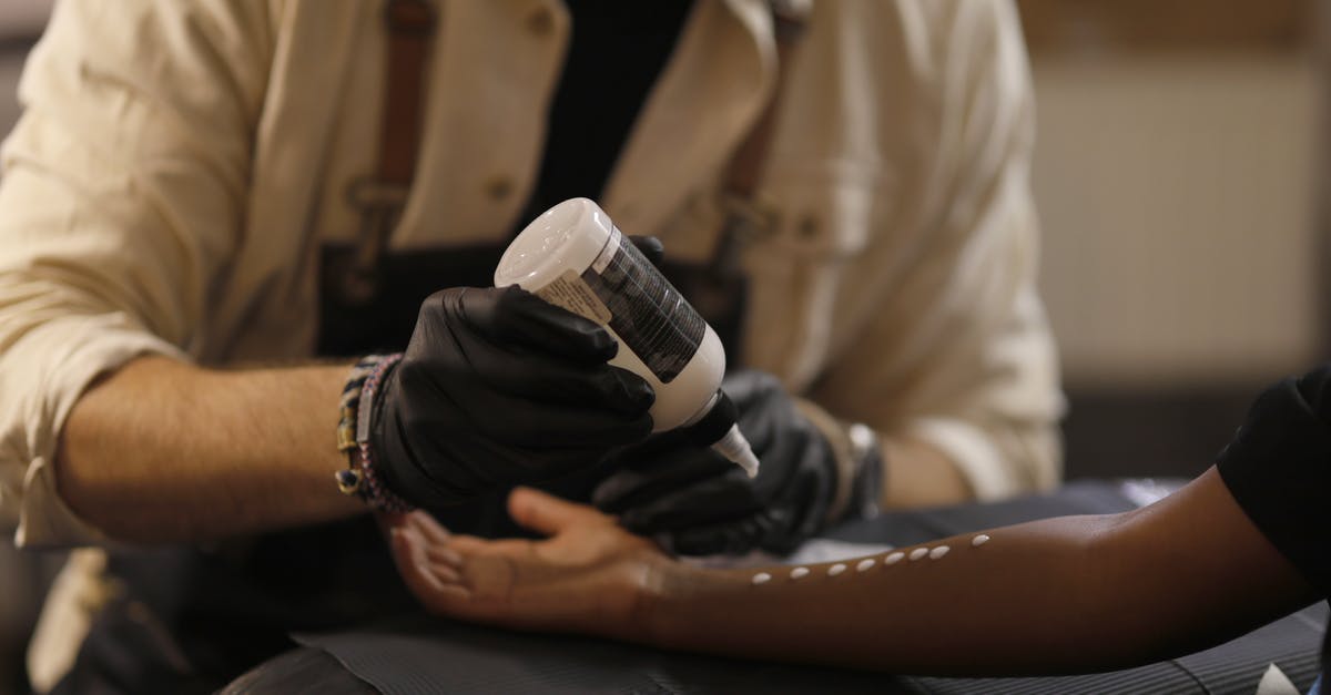 Are there sterile transfer areas in Juan Santamaria airport? - Unrecognizable crop male tattooist in black latex gloves and apron pouring tattoo transfer gel on arm of black female client in modern salon Are there sterile transfer areas in Juan Santamaria airport? - Unrecognizable crop male tattooist in black latex gloves and apron pouring tattoo transfer gel on arm of black female client in modern salon