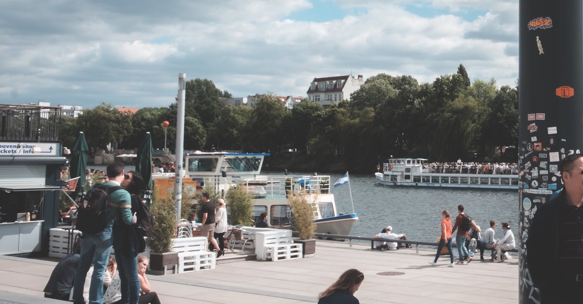 Are there still many refugees on the Copenhagen-Hamburg train? - Crowd of people walking at port with ships near tranquil rippling river under cloudy sky in daytime Are there still many refugees on the Copenhagen-Hamburg train? - Crowd of people walking at port with ships near tranquil rippling river under cloudy sky in daytime