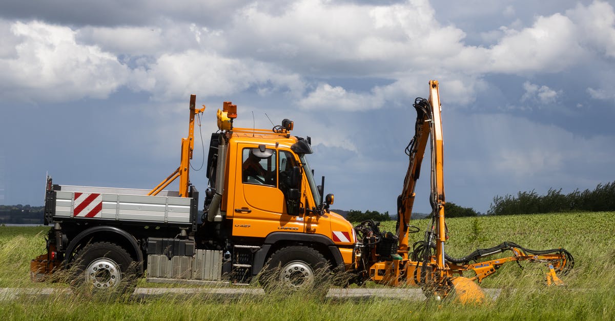Are vignettes needed to drive on German motorways? - Orange Mercedes-Benz Unimog mowing the grass stripes next the road Are vignettes needed to drive on German motorways? - Orange Mercedes-Benz Unimog mowing the grass stripes next the road