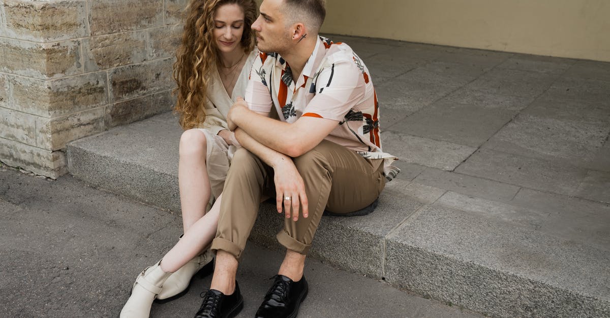 Arriving Before Visa Start Date - Man and Woman Sitting on Concrete Bench Arriving Before Visa Start Date - Man and Woman Sitting on Concrete Bench