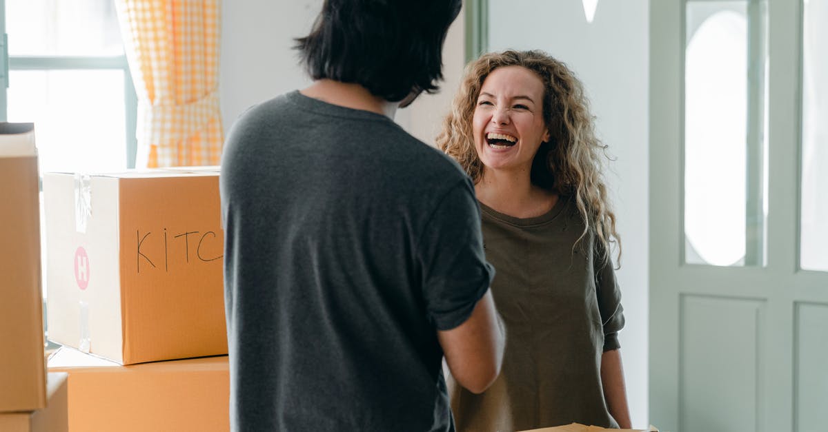 As a married couple with different citizenships, should we pass through US immigration together or separately? - Joyful woman interacting with boyfriend near pile of boxes As a married couple with different citizenships, should we pass through US immigration together or separately? - Joyful woman interacting with boyfriend near pile of boxes