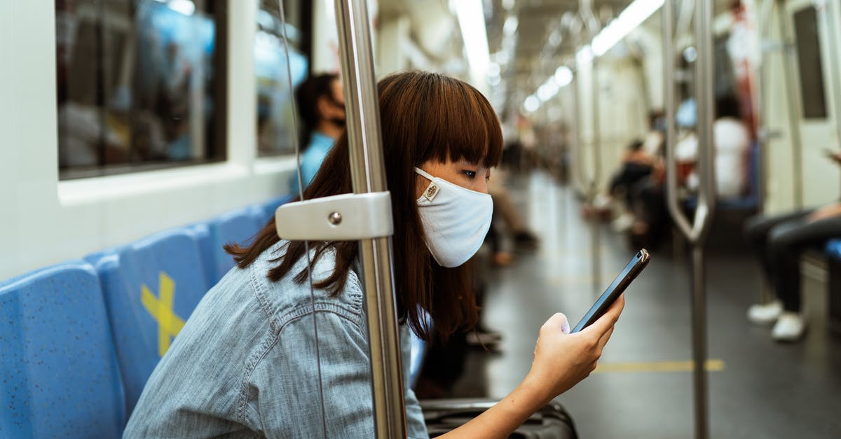 As an expat, can you rely on travel insurance in case of the Coronavirus becoming a widespread major pandemic? - Woman Wearing a Face Mask and Holding a Smartphone As an expat, can you rely on travel insurance in case of the Coronavirus becoming a widespread major pandemic? - Woman Wearing a Face Mask and Holding a Smartphone