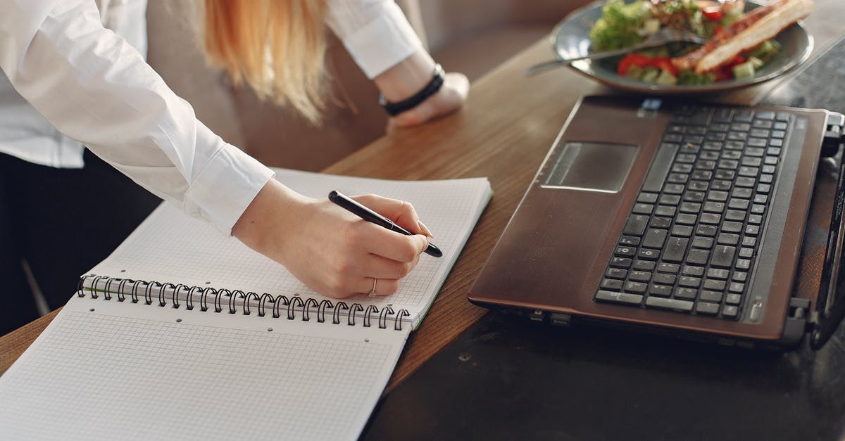 As an Indian, can I work part time in Italy on a Schengen study visa? [closed] - From above of crop anonymous female freelancer writing with pen in copybook while standing near table with laptop and plate of food for lunch in cafeteria