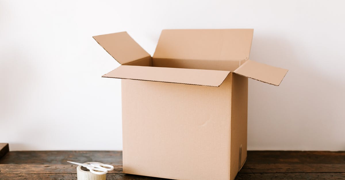 At JFK, can you move between terminals airside on domestic flights? - Opened cardboard container placed on old wooden desk near tape and scissors before relocation against white wall At JFK, can you move between terminals airside on domestic flights? - Opened cardboard container placed on old wooden desk near tape and scissors before relocation against white wall