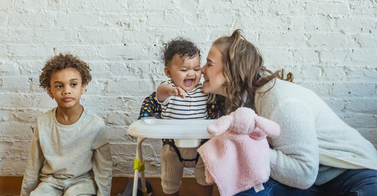 At what age an infant can start flying? - Happy mother sitting and playing with children At what age an infant can start flying? - Happy mother sitting and playing with children