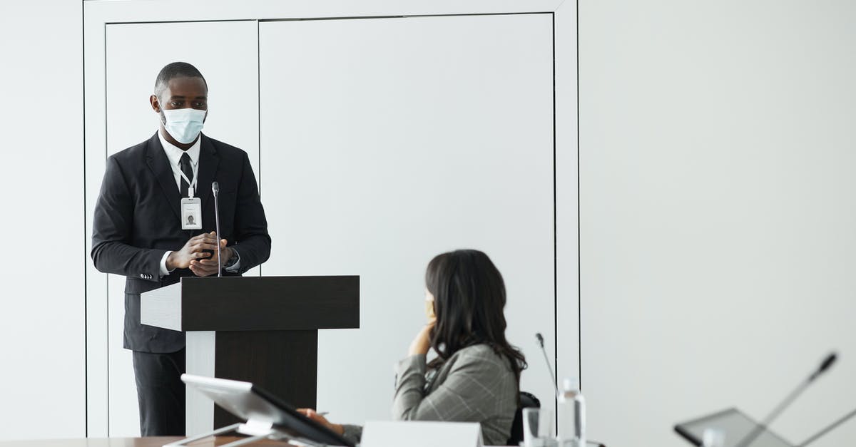 Attending a conference in Beijing with special dietary needs - Man in Black Suit Jacket Sitting on Chair in Front of Woman in Black Long Sleeve Attending a conference in Beijing with special dietary needs - Man in Black Suit Jacket Sitting on Chair in Front of Woman in Black Long Sleeve