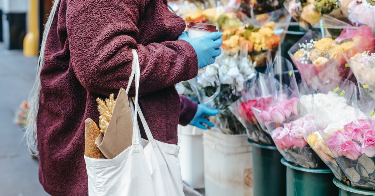 Australia: How to know price of goods in groceries - Woman with paper cup of coffee buying flowers on street Australia: How to know price of goods in groceries - Woman with paper cup of coffee buying flowers on street