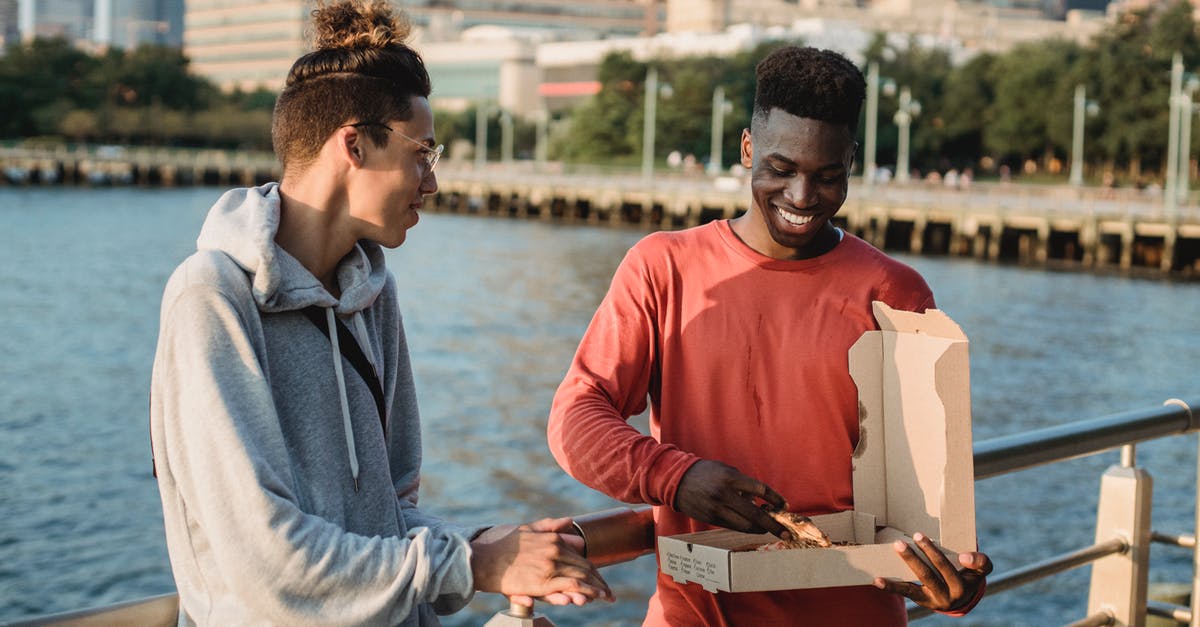 Australians awaiting Italian permit to stay - can they go to the UK and return? - Cheerful young multiracial male friends in casual clothes standing on city embankment and eating delicious Italian pizza Australians awaiting Italian permit to stay - can they go to the UK and return? - Cheerful young multiracial male friends in casual clothes standing on city embankment and eating delicious Italian pizza