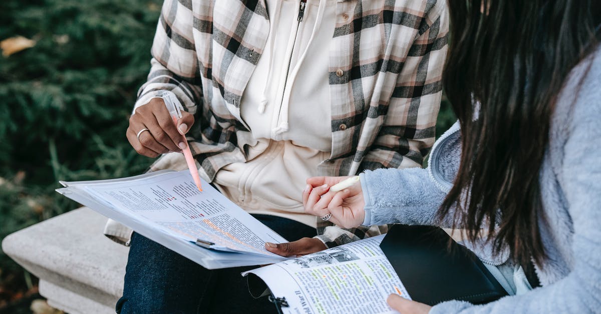 AUS/UK dual citizen entering the UK on AUS visa with student visa and taking partner as dependant [closed] - High angle of crop concentrated diverse female students taking notes with markers in documents with printed texts sitting on stone bench in campus