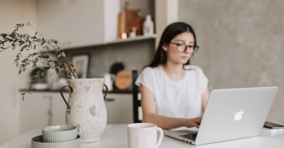 Automated passport kiosks, deferral with ER using Green Card - Focused young businesswoman working remotely at home Automated passport kiosks, deferral with ER using Green Card - Focused young businesswoman working remotely at home