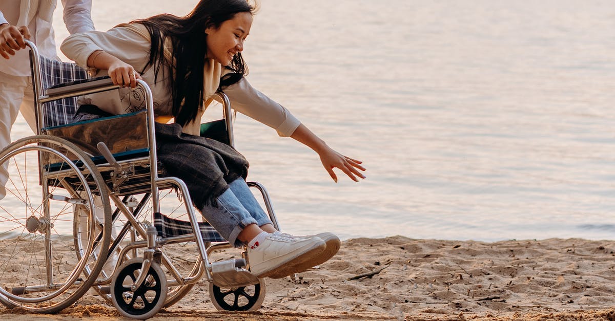 bags and wheelchair - Woman in Black Tank Top Sitting on Blue and Gray Wheelchair on Beach bags and wheelchair - Woman in Black Tank Top Sitting on Blue and Gray Wheelchair on Beach