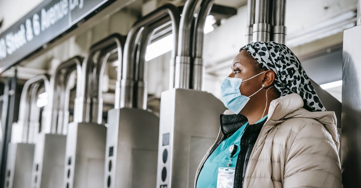 Belgian Rail Pass and RailPlus pass. Which to use to travel from a Belgian station to Roosendal, Aachen or Maastricht? - Side view emotionless African American female doctor wearing warm clothes and protective face mask passing through turnstile gates in New York underground Belgian Rail Pass and RailPlus pass. Which to use to travel from a Belgian station to Roosendal, Aachen or Maastricht? - Side view emotionless African American female doctor wearing warm clothes and protective face mask passing through turnstile gates in New York underground