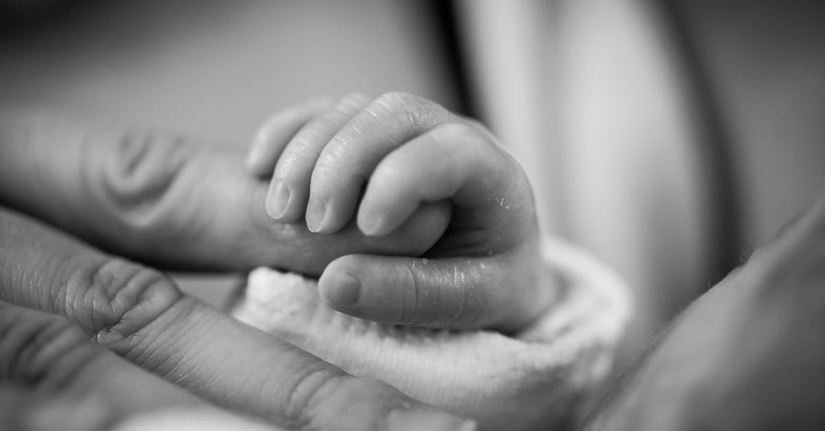 Belize with two small children [closed] - Grayscale Photography of Baby Holding Finger