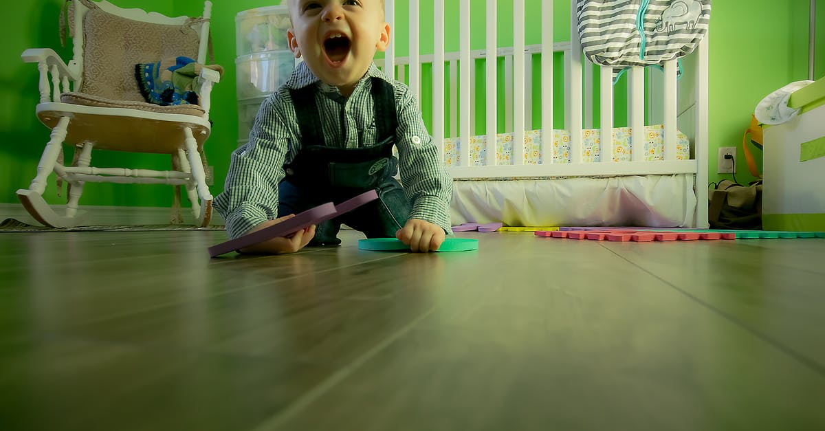 Below standard baby crib - Full Length of Boy Sitting on Floor Below standard baby crib - Full Length of Boy Sitting on Floor