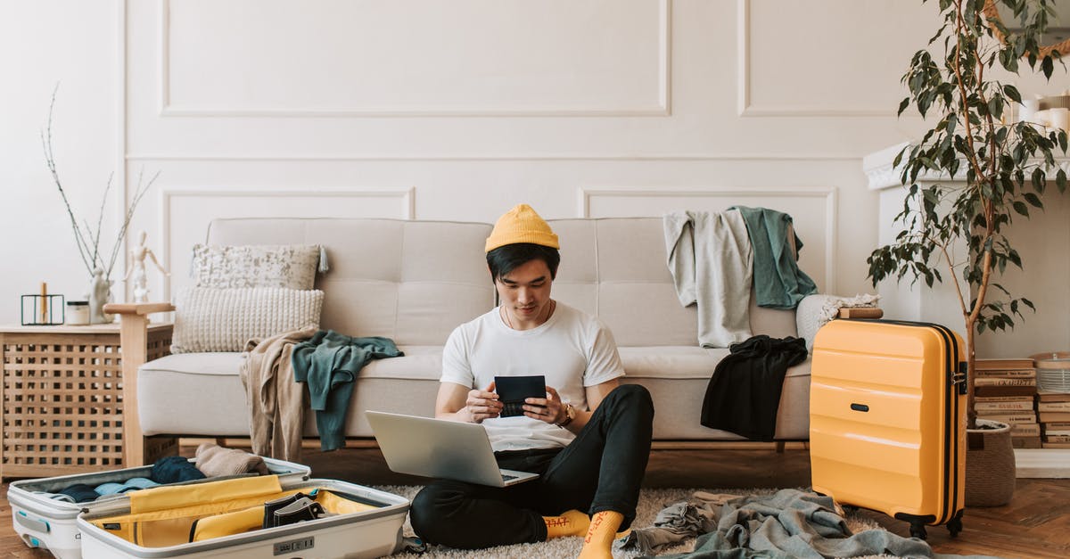 Benefits of checking in online when checking bags - A Man Using His Laptop in a Messy Living Room Benefits of checking in online when checking bags - A Man Using His Laptop in a Messy Living Room