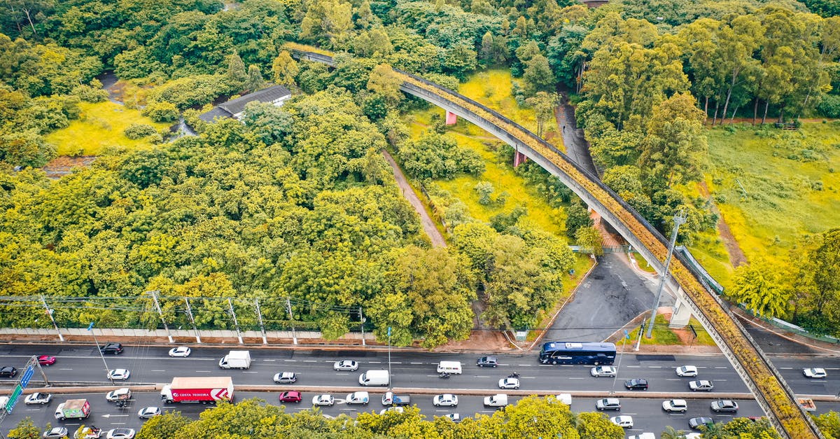 Best Route from Zurich Airport to Rhine Falls - Drone view of urban bridge and roadway with transport between colorful lush woods in fall Best Route from Zurich Airport to Rhine Falls - Drone view of urban bridge and roadway with transport between colorful lush woods in fall