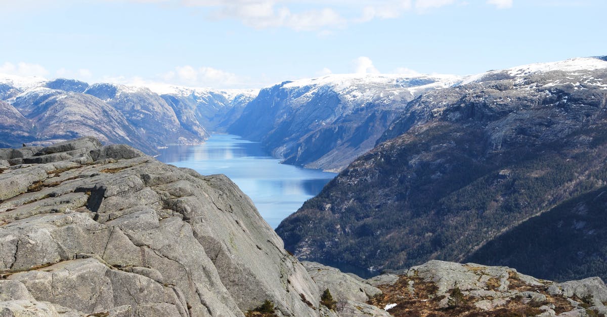 Best season for Norway fjords cruise? - Breathtaking view of calm cold lake surrounded with rocky hills covered with snow under blue sky Best season for Norway fjords cruise? - Breathtaking view of calm cold lake surrounded with rocky hills covered with snow under blue sky