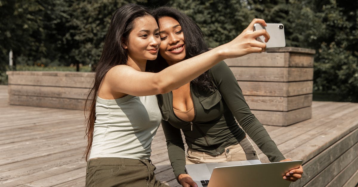 Best strategy to get a cheap long-term mobile SIM card for the US? - Positive young multiethnic ladies with long dark hairs in casual outfits smiling and taking selfie on mobile phone while chilling in park with laptop Best strategy to get a cheap long-term mobile SIM card for the US? - Positive young multiethnic ladies with long dark hairs in casual outfits smiling and taking selfie on mobile phone while chilling in park with laptop
