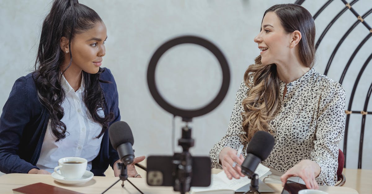 Best town to live and work over the Internet in Sicily / Italy [closed] - Positive blogger asking questions to African American speaker and recording interview on cellphone at table with microphones