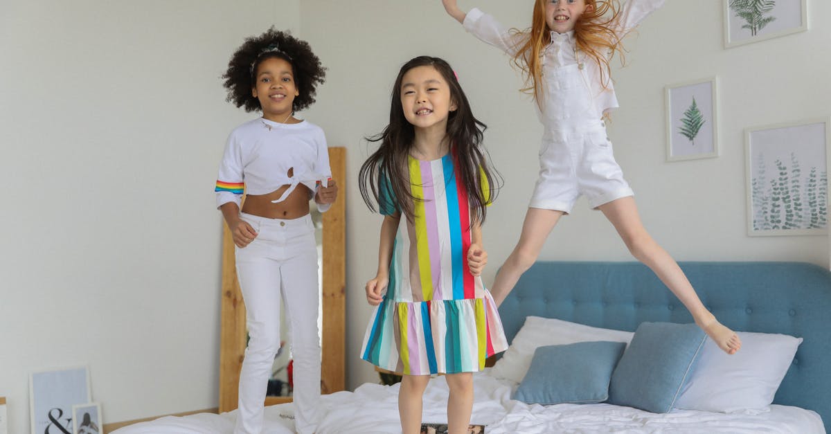 Best visa for the UK if buying a holiday home - Cheerful diverse girls having fun and jumping on soft bed with pastel pillows in contemporary room Best visa for the UK if buying a holiday home - Cheerful diverse girls having fun and jumping on soft bed with pastel pillows in contemporary room