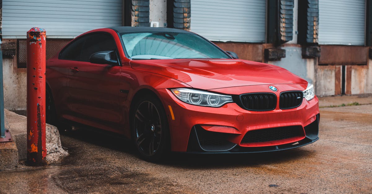 Best way to deal with a rental car in the Domincan Republic? [closed] - Contemporary red automobile with headlight light parked on sidewalk near building with closed blinds windows in city on street outside