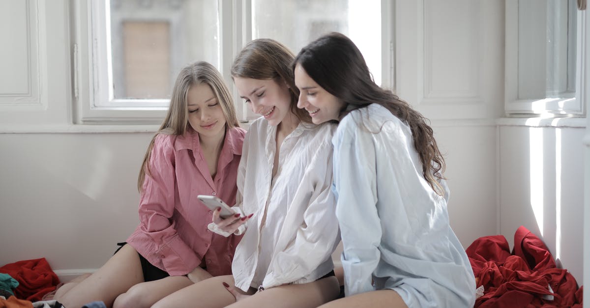 Best way to send valuable item back home while travelling (Istanbul)? - Group of young women browsing smartphone together in messy room