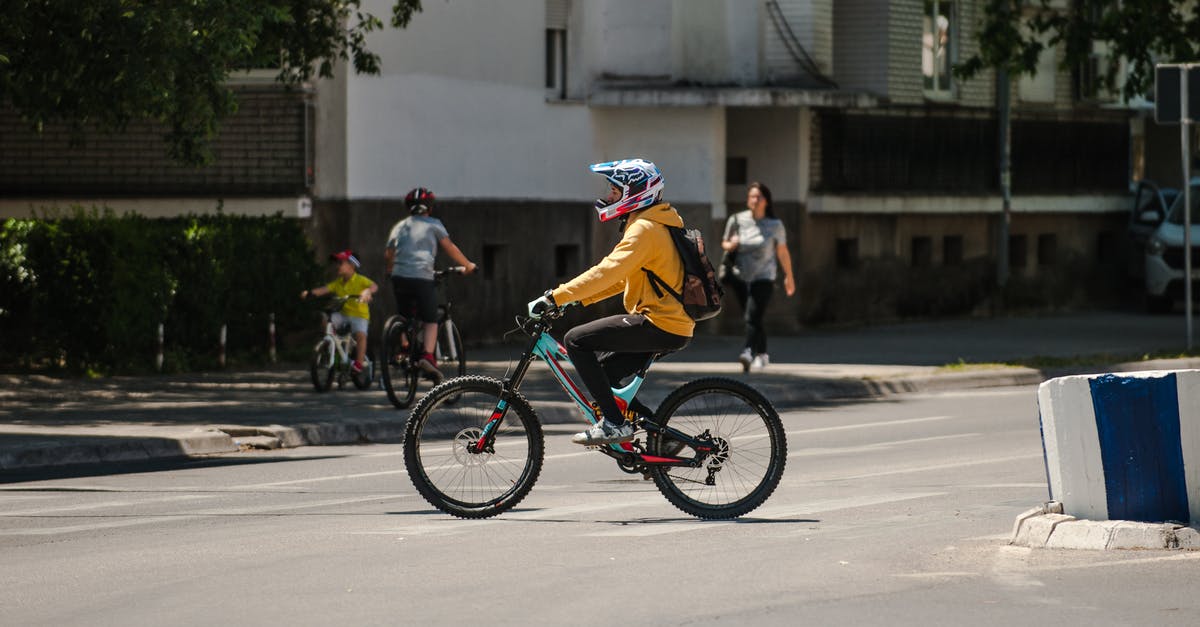 Bicycle helmet and backpack as carry-on in the US? - Unrecognizable biker riding bicycle on city road Bicycle helmet and backpack as carry-on in the US? - Unrecognizable biker riding bicycle on city road