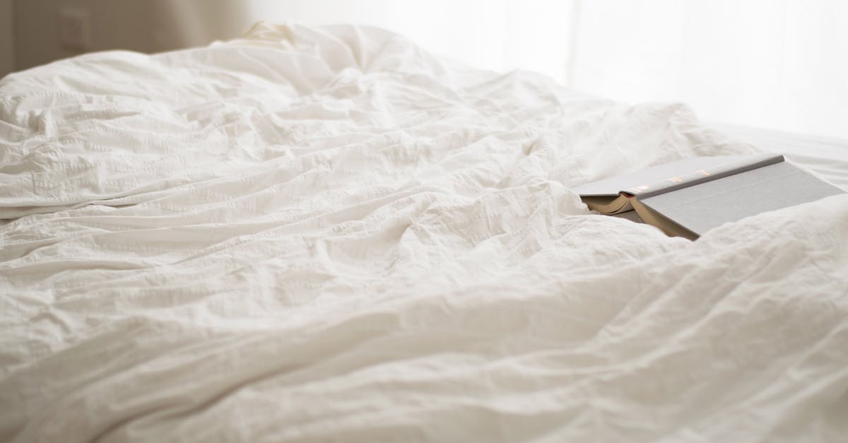 Booking a hotel for unusual hours - Black and Beige Book on White Bed Sheet Booking a hotel for unusual hours - Black and Beige Book on White Bed Sheet