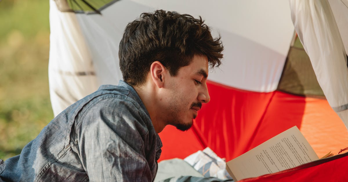 Booking repeat round trip every weekend - Traveler reading textbook in tent during summer journey Booking repeat round trip every weekend - Traveler reading textbook in tent during summer journey