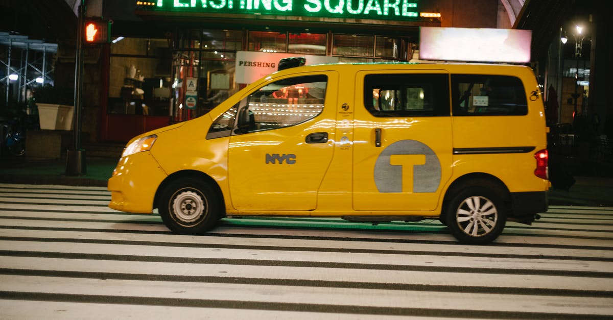 Boro cab service in New York City - Shiny yellow van taxi parked on street near entrance of cafe with neon sign in New York at night Boro cab service in New York City - Shiny yellow van taxi parked on street near entrance of cafe with neon sign in New York at night