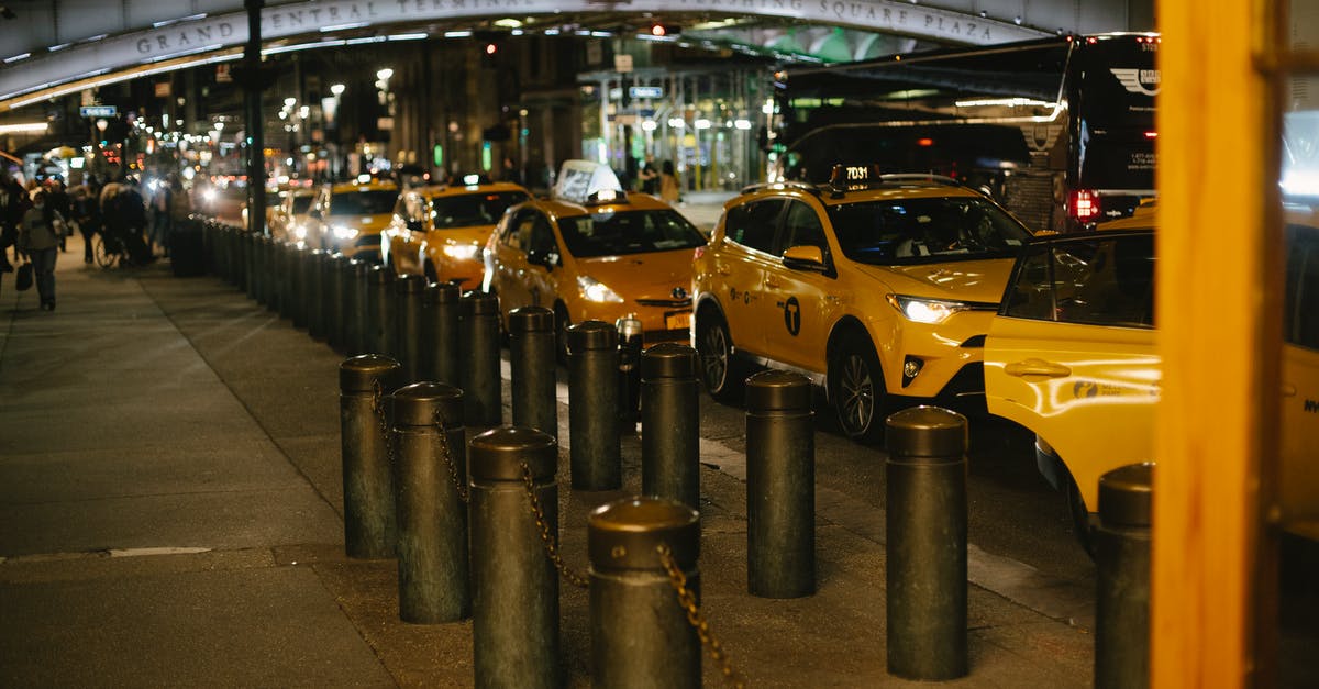 Boro cab service in New York City - Row of modern shiny yellow taxis with glowing headlights parked at roadside near Grand Central Terminal in New York at night Boro cab service in New York City - Row of modern shiny yellow taxis with glowing headlights parked at roadside near Grand Central Terminal in New York at night