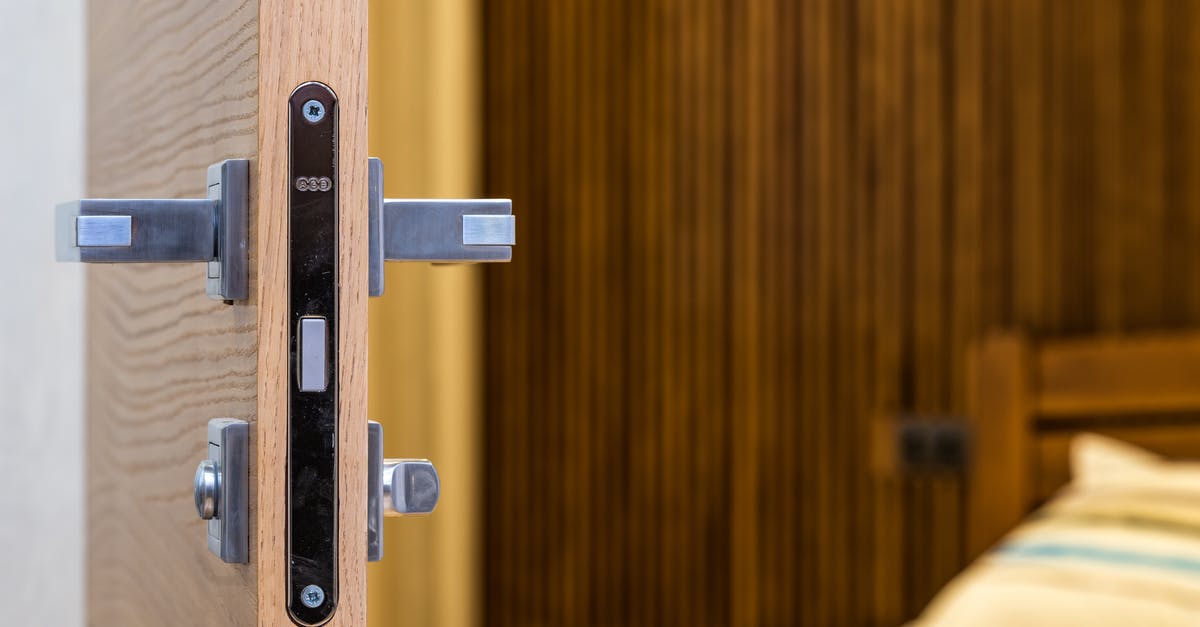 Bought new TSA suitcase, it's locked itself - how to open it? - Opened doorway with lock and simple metal handle in light room with wooden bed Bought new TSA suitcase, it's locked itself - how to open it? - Opened doorway with lock and simple metal handle in light room with wooden bed