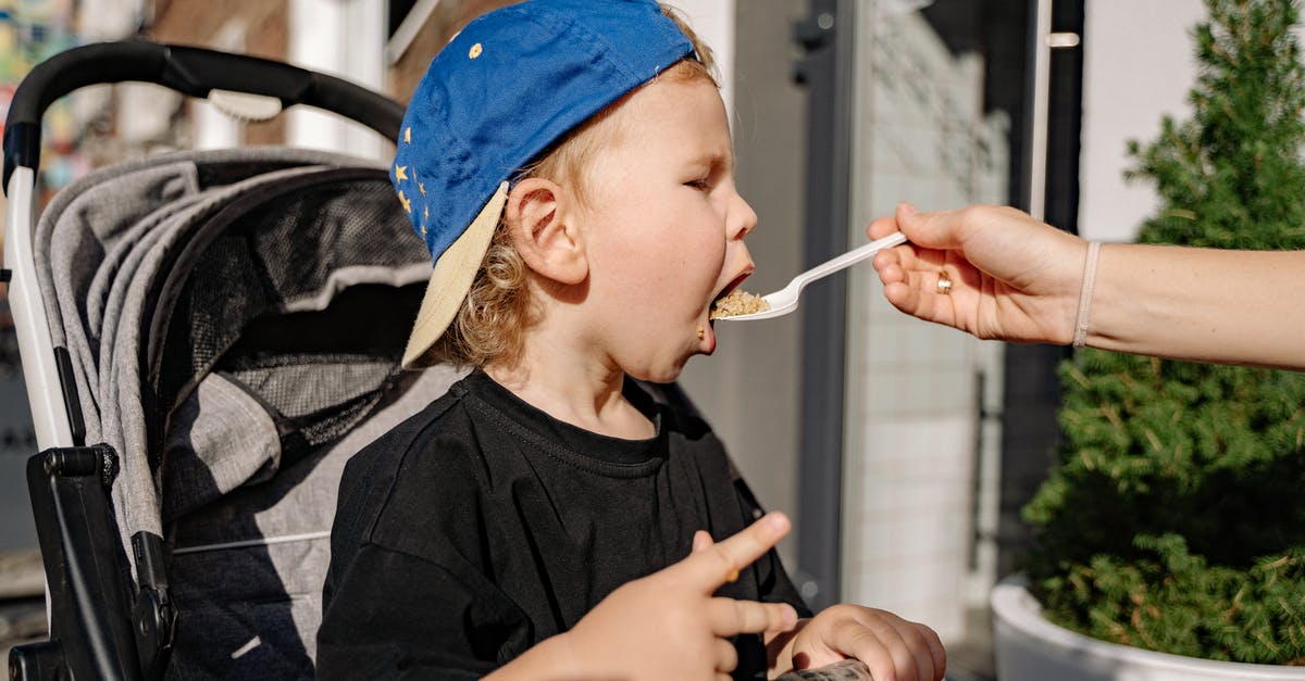 Bring baby food through TSA - Woman in Black Crew Neck T-shirt and Blue Cap Holding Black Dslr Camera