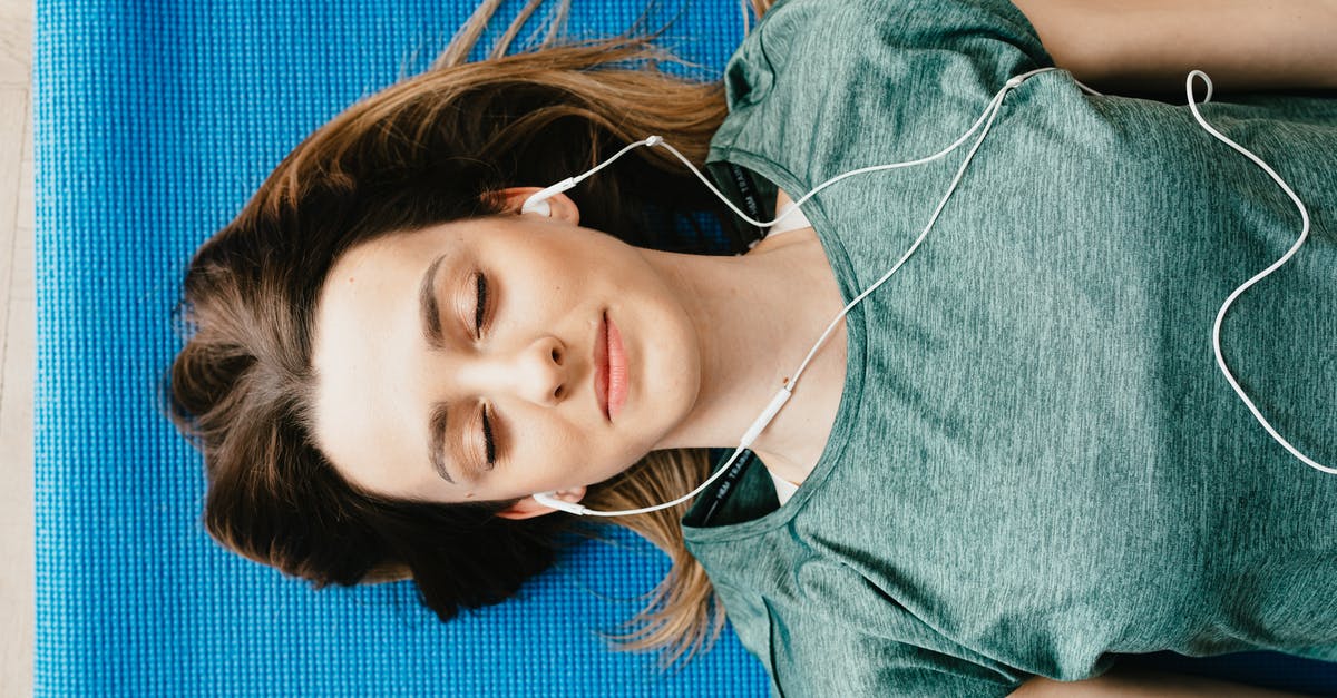 Bringing gemstones from Madagascar to an auction house in Switzerland [closed] - Tranquil woman resting on yoga mat in earphones at home
