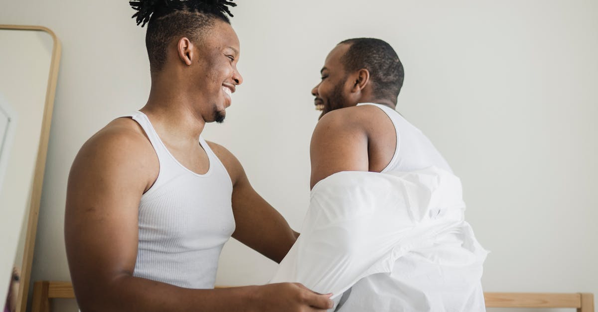 Brussels to Les Arcs for skiing, other than by car? [closed] - Man Taking Off Shirt from Other Man in Bedroom