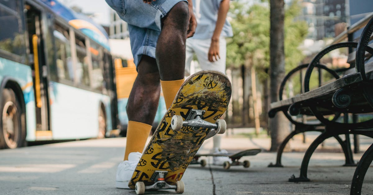 Bus times from Anuradhapura to Kandy? - Crop unrecognizable male in yellow socks standing on colorful skateboard tail and deck at angle with friend while waiting for bus on bus stop Bus times from Anuradhapura to Kandy? - Crop unrecognizable male in yellow socks standing on colorful skateboard tail and deck at angle with friend while waiting for bus on bus stop