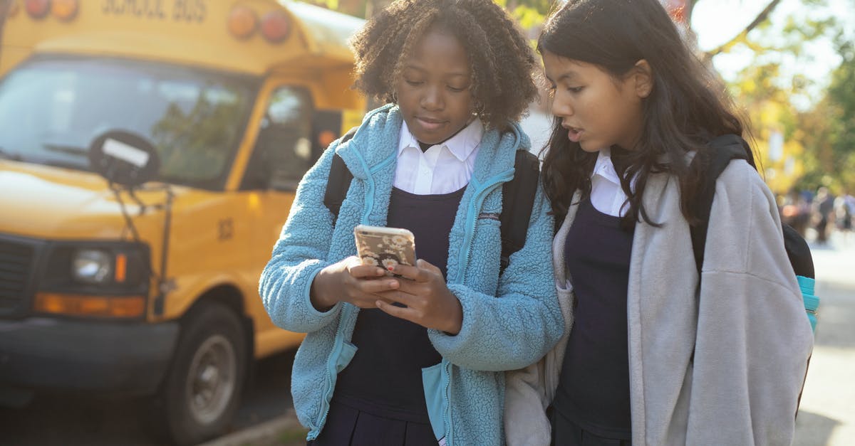 Bus times from Anuradhapura to Kandy? - Diverse schoolgirls surfing smartphone on sunny street Bus times from Anuradhapura to Kandy? - Diverse schoolgirls surfing smartphone on sunny street